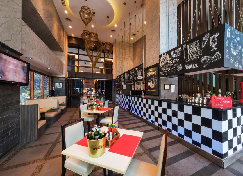 Swiss-Belhotel Mangga Besar in Jakarta shows a stylish checkered café counter and dining area.