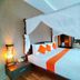 Jingjit Hotel Krabi bedroom with four-poster bed, white canopy drapes, and orange accents