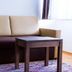 Hotel Vinothek Schwarzer Adler in Ottensheim: beige sofa with nested wooden tables and rug