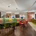 Home2 Suites by Hilton Salt Lake City/Layton lobby with green sectional seating and red chairs in Layton