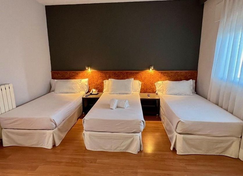 Shs Hotel Aeropuerto Madrid triple room with three single beds and bedside lamps