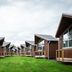 Tromsø Lodge & Camping in Tromsø, row of modern wooden cabins with grassy courtyard