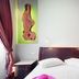 Splanzia Boutique Hotel in Chania, bed with white linens and carved wood wall art