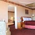 Regency Inn Richmond guest room with king bed, chair, and bathroom vanity in Richmond