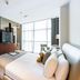 S31 Sukhumvit Hotel in Bangkok guest room with king bed, TV, balcony doors and city-view curtains