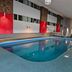 Indoor pool at Howard Johnson by Wyndham Woodstock NB in Woodstock with ladder and lounge chairs