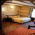 Residence Ruetoreif in Gressoney-Saint-Jean room with wood-paneled walls, bed and rustic dining area