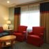 The Cove at Yarmouth by Westgate Resorts living room with sofa, red chairs, lamp, and window