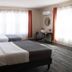 The Marquette Hotel in Madison guest room with two beds, large windows, and a small desk