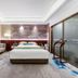 Anhui Construction New Era Hotel in Bengbu guest room with king bed, sofa, and city-view window