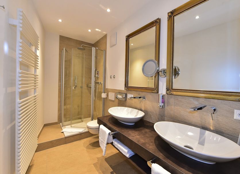 Schloss Hotel Wasserburg bathroom with double sinks, mirrors and glass walk-in shower in Wasserburg am Bodensee