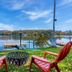 Candlewood Suites Kenedy By IHG lakeside fire pit with red chairs and dock on a calm lake