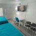 Uptown Inn & Suites in St. Petersburg room with two turquoise beds, desk, TV and seating area