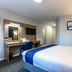 Days Inn by Wyndham London Stansted Airport guest room with double bed, desk, chair and wall-mounted TV in Bishop's Stortford