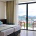 Oak Ray Heritage Hotel in Kandy bedroom with king bed and balcony view of the city and hills