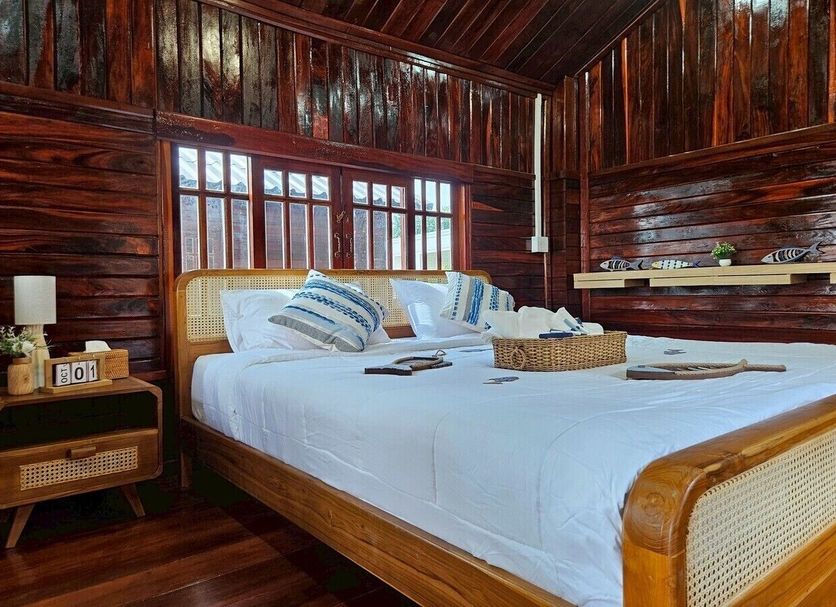 I-Lay House Koh Kood bedroom in Ko Kut with wooden walls, king bed, and tropical island style decor
