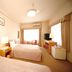 Tokyo Buc Nakagin hotel room in Tokyo with two beds, desk, TV, and large window