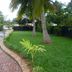 Grand Crown Hotel in Anuradhapura with landscaped lawn, palm trees, and brick driveway