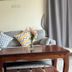Aforetime Beach House in Ko Samui features a gray sofa, wooden coffee table, and chevron pillows.
