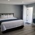 The Palms On Ocean in Pompano Beach guest room with king bed, nightstand, and light wood flooring