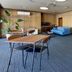 Hotel Sun Abashiri lounge with blue sofa, dining tables, potted plants and TV in Abashiri