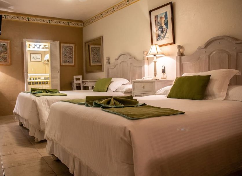 Villa Mirasol in San Miguel de Allende guest room with two twin beds, bedside lamp, and green accents