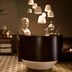 QT Sydney in Sydney lobby bar with curved dark wood counter, pendant lights and checkered floor
