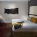 QT Sydney hotel room in Sydney with king bed, desk, wall art and TV