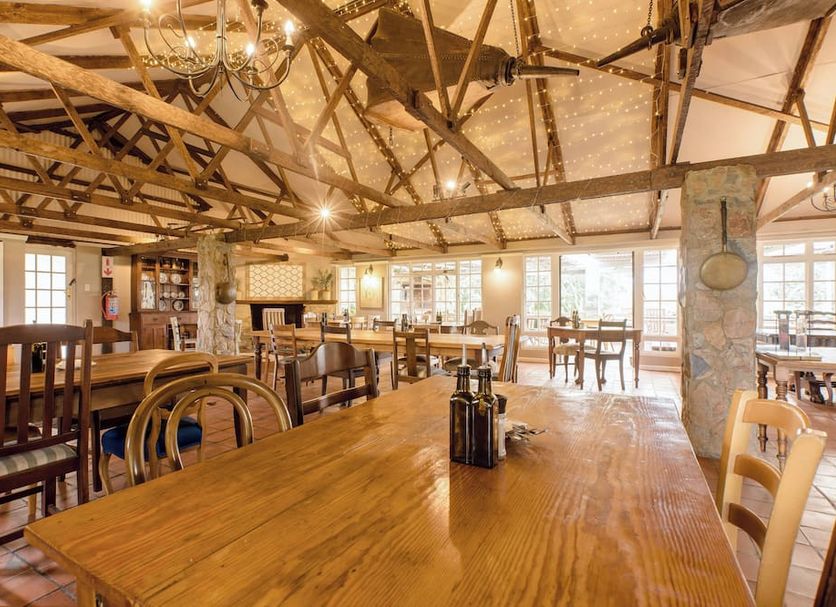 Portland Manor Knysna rustic hotel dining room with wooden beams and tables