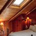 Chalet of Canandaigua attic bedroom with sloped wood ceiling, wrought-iron bed, and skylight