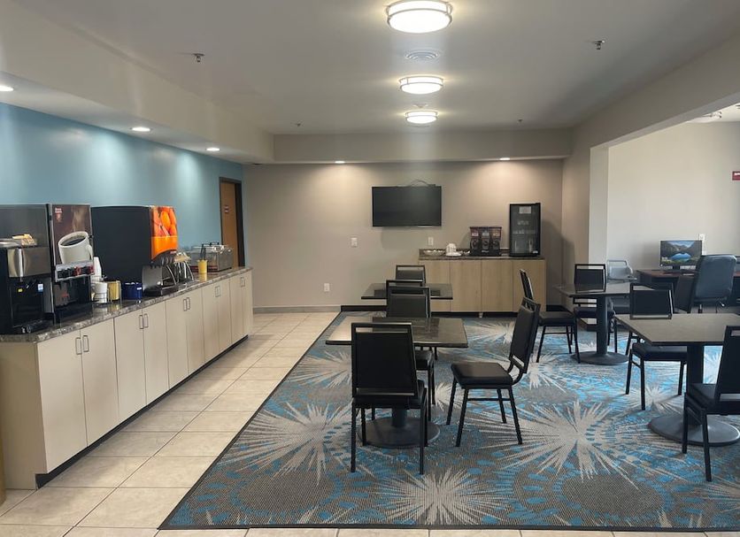Days Inn by Wyndham Jefferson City breakfast area with tables, chairs, coffee station and TV