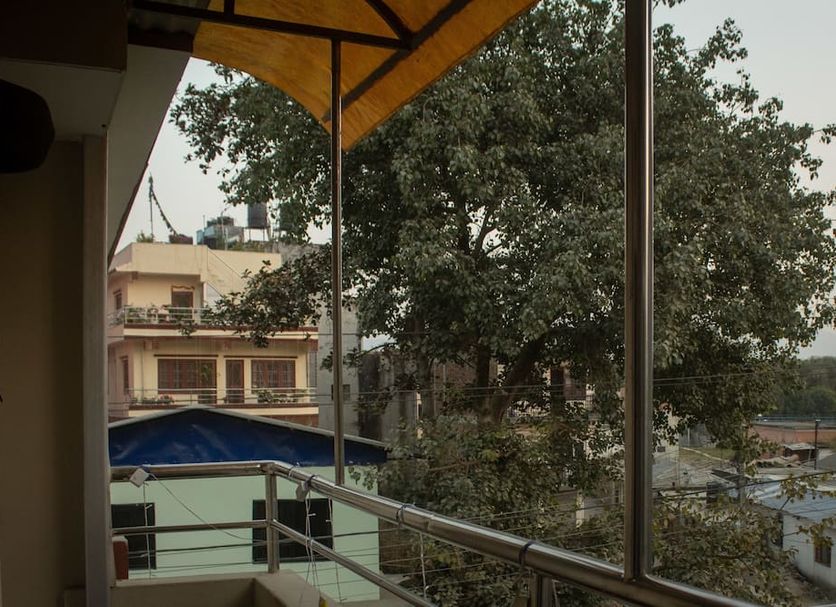 Sudha's Garden Home in Kathmandu balcony view with trees, nearby buildings, and an awning
