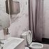 Paraiso Hostel Barcelona bathroom with shower curtain, toilet, and wall-mounted sink