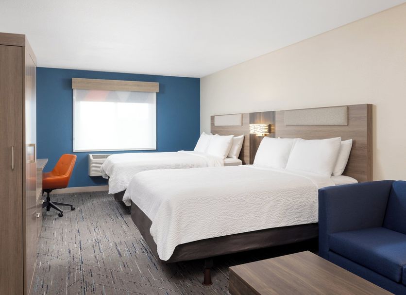 Holiday Inn Express Portland South - Lake Oswego guest room with two beds, blue accent wall and seating area
