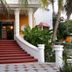 Mansion Giahn Bed & Breakfast in Cancún, red staircase entrance framed by palm trees and white columns