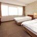 Fukuyama Terminal Hotel guest room with two beds, large window, and patterned wallpaper in Fukuyama