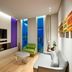 Aloft Seoul Gangnam lounge with TV, green chair, sofa, and city-view windows in Seoul