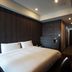 Benikea Hotel Haeundae, Busan guest room with king bed, wall-mounted TV and modern dark wood décor