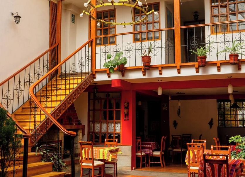 Hotel La Posada de Atahualpa Cusco courtyard with staircase, balcony, and outdoor dining area