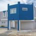 Casa Toñita in Levittown, blue-and-white two-story hotel exterior with covered parking