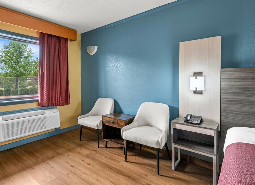 Econo Lodge Charlotte Airport Area room in Charlotte with two chairs, table, window and wall-mounted AC