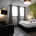 Ferien Appartements Am Berghotel Oberhof room with double bed, sloped ceiling, and green accent wall