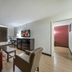 Red Roof Inn & Suites Denton room with sofa, chair, desk, TV and window blinds