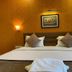 Hotel Sagar Kanya Inn Puri bedroom with king bed, patterned walls, and warm wall sconces