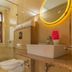 Hotel Woodrina bathroom in Shimla with illuminated round mirror, sink, shower and toilet