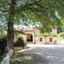 Agriturismo Il Casale Degli Amici in Norcia with a tree-lined courtyard and rustic farmhouse exterior