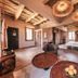 Ksar Ighnda in Aït Ben Haddou guest room with woven pendant lights, twin beds and rustic seating