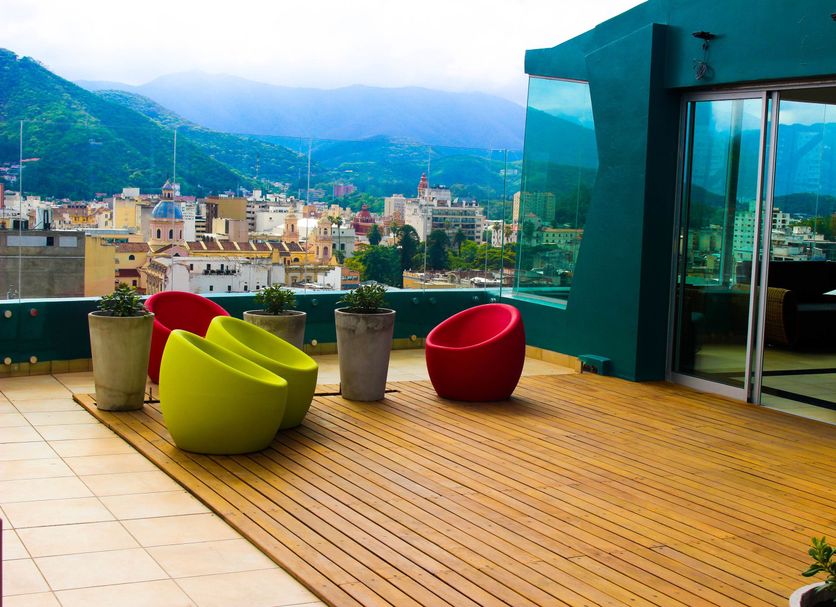 Brizo Salta rooftop terrace with colorful chairs and mountain city views in Salta