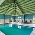 Holiday Inn Express & Suites Ada By IHG indoor pool with lounge chairs and green vaulted ceiling