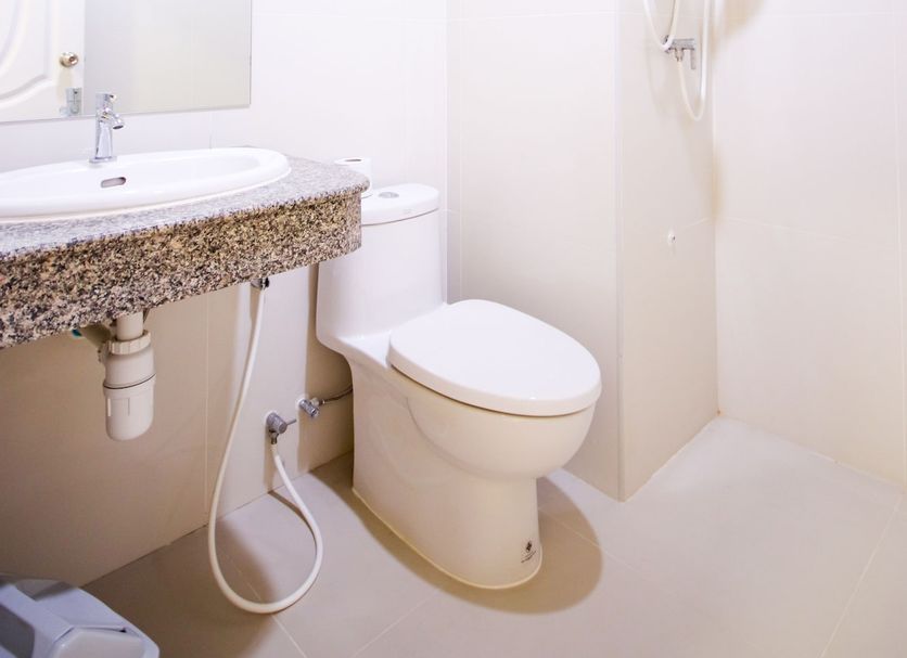 White House Bizotel in Bangkok bathroom with sink, toilet, and wall-mounted shower